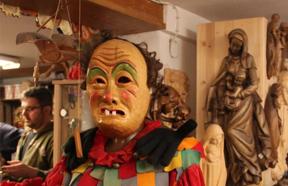 Chez le sculpteur, les masques de carnaval cohabitent avec les statues religieuses.