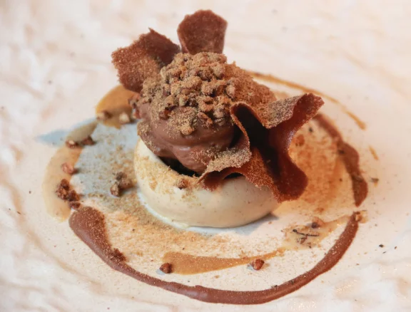 Dessert au chocolat noir décliné en mousse, en glace et en tuile avec un parfait au noix, riz soufflé et shiitaké rapé.