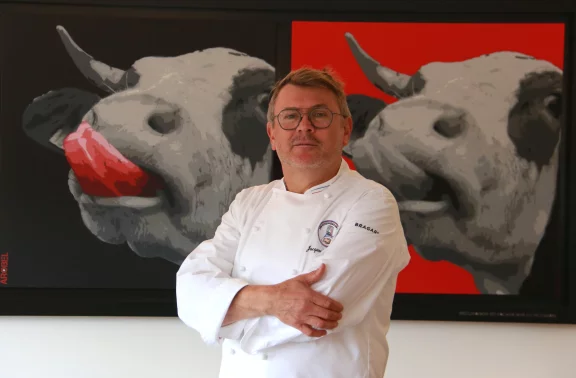 Jacques Barnachon devant une toile symbolisant la renaissance de la vache montbéliarde est aussi membre de l'association des maîtres cuisiniers de France.
