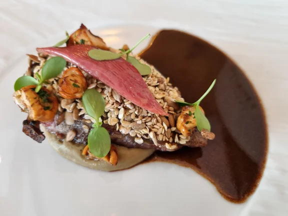 Pigeon pané aux céréales et servi sur une pulpe d'aubergines.