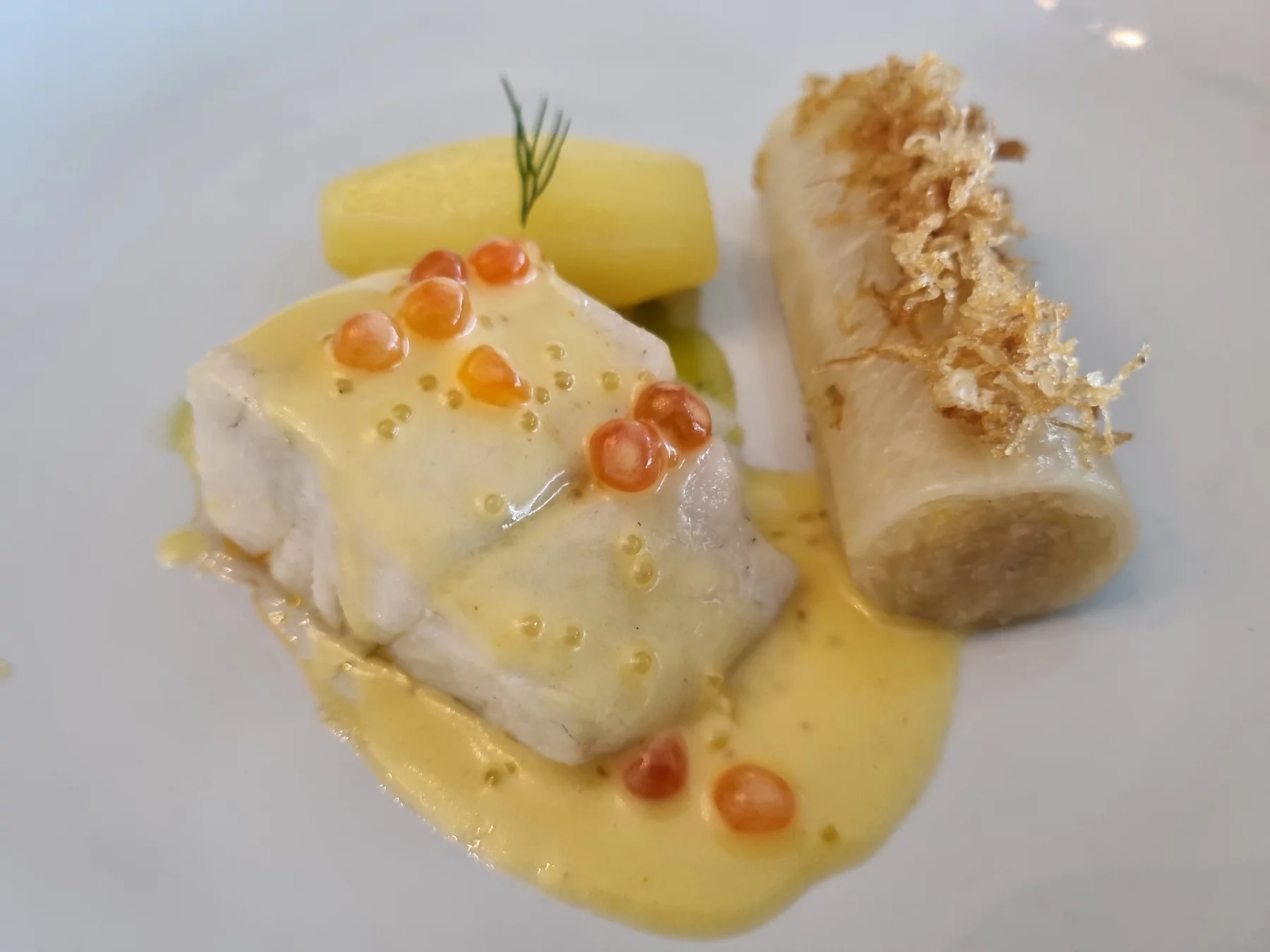 Sandre travaillé avec de l'huile de colza, pommes de terre, caneloni de choucroute nouvelle, sauce au beurre blanc, oeufs de saumon et de brochet.