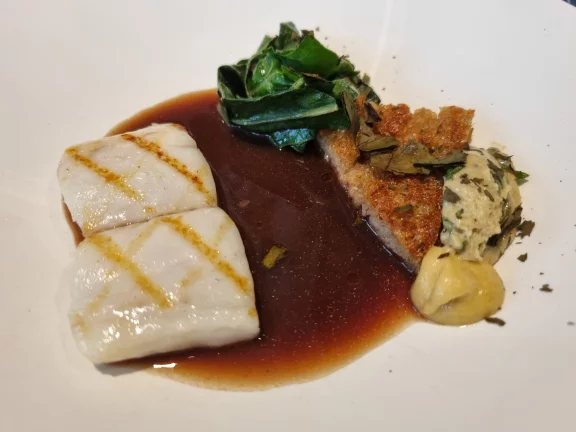 Bar servi nacré avec des blettes, son gateau de pain perdu, moutarde fumée et une bearnaise avec le colagène du poisson et un jus de blettes corsé.