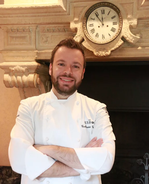 Guillaume Guidet devant la cheminée où sont gravées les initiales des prénoms des enfants Rothschild.