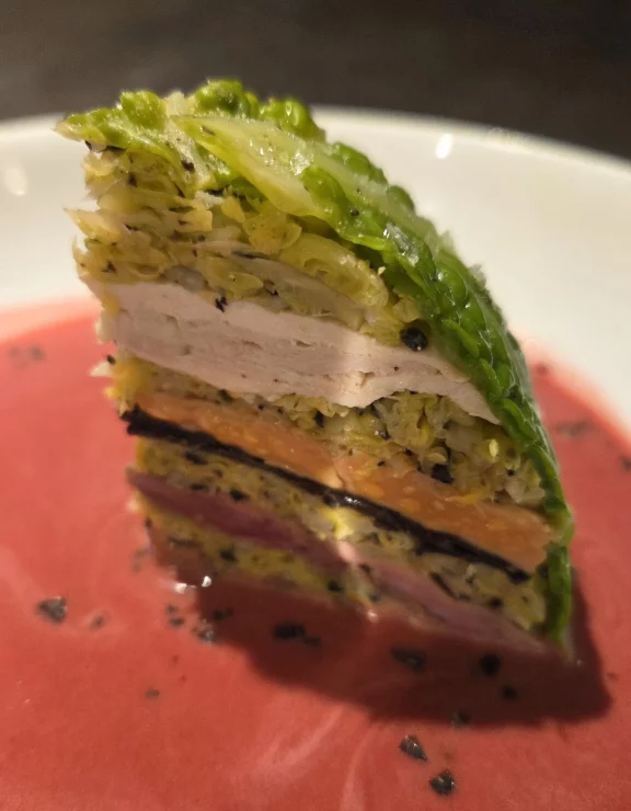 Choux pressé, farci de gibier à plumes, foie gras, truffes noires et consommé de bétteraves crues.