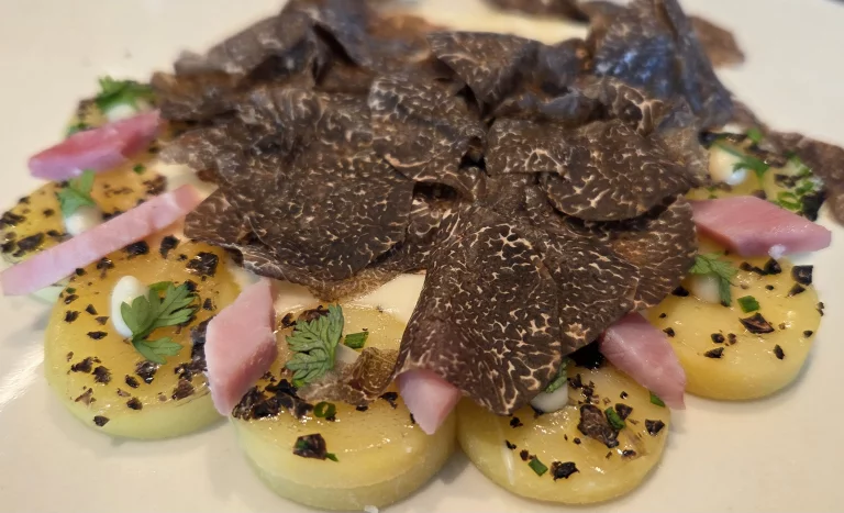 Lamelles de pommes de terre, jambon cuit, vacherin de la vallée de Joux et copeaux de truffes d'hiver.
