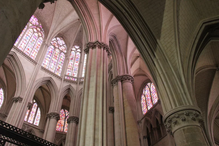 En journée, les vitraux habillent les colonnes de la cathédrale de couleurs douces.