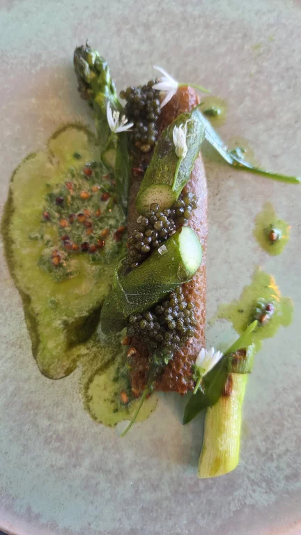 Asperges vertes cuites au barbecue, tranche de lard, tomme au lait de brebis, sarrasin soufflé et caviar.