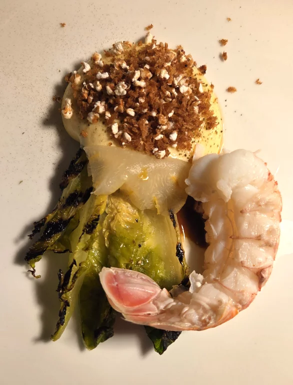 Langoustine cuite à l'eau de mer, feuilles de sucrine, mayonnaise et pop-corn de sarrasin.