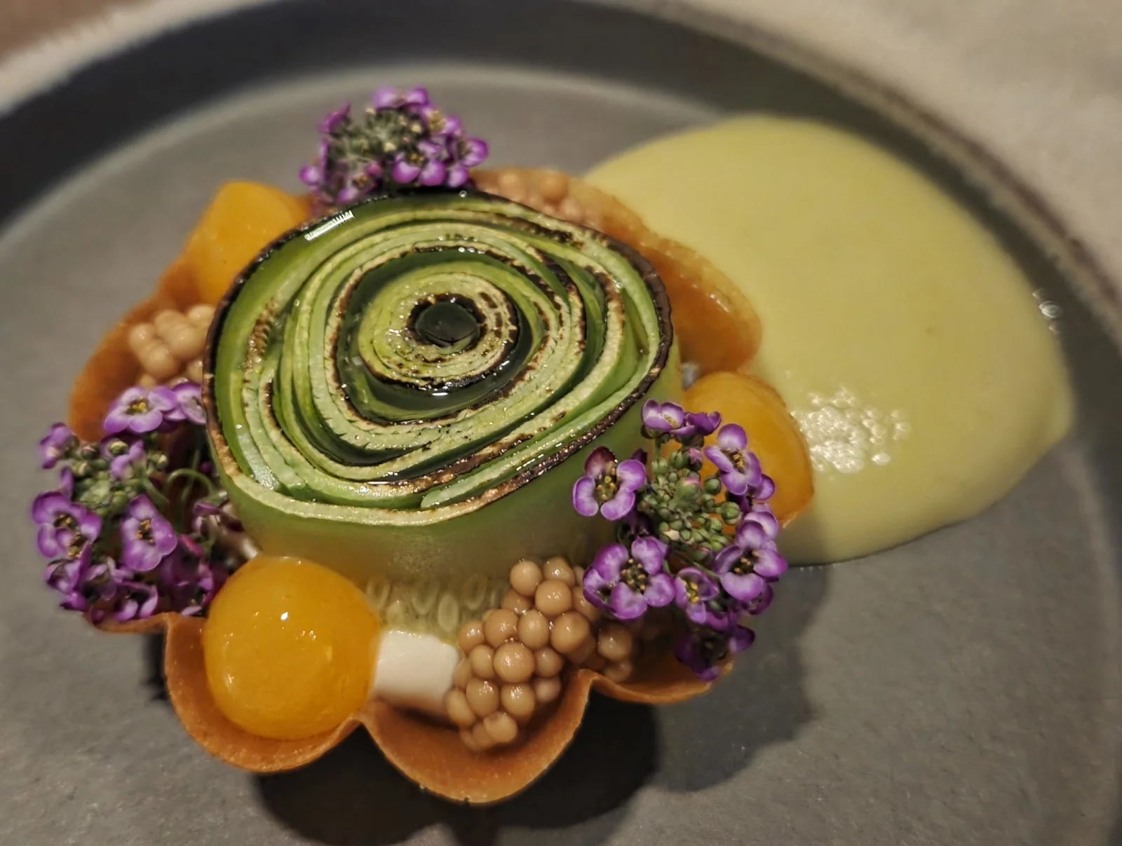 Tartelette végétale avec courgette violon, fromage frais, oeufs confits, pickel de moutarde et coulis de basilic.