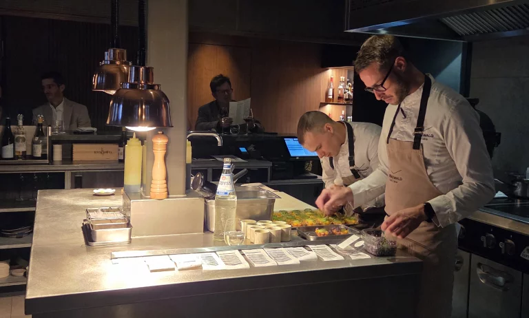 La cuisine est ouverte sur un comptoir où les clients sont attablés.