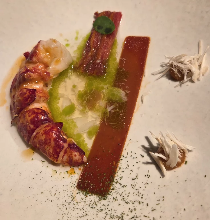 Homard bleu avec son mille feuilles et sa purée de tomates accompagnés d'un bouillon de livèche.