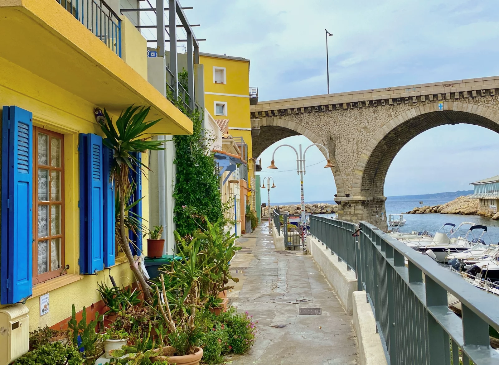 Les façades colorées du Vallon des Auffes et sous le viaduc, face à la mer, le restaurant Auffo, autrefois L'Epuisette.