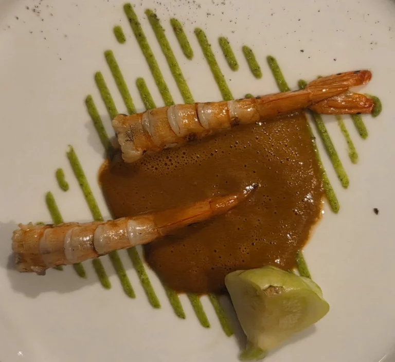 Gamba juste rôtie à la braise avec sa crème de courgettes au cumin et son jus de tête aux graines anisées.