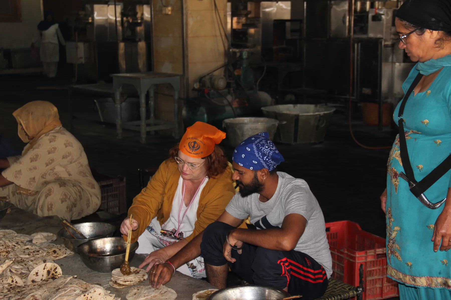 Sous le regard attentif d'une femme sikh, elle porte une petite dague, même les touristes peuvent aider à la préparation des repas.