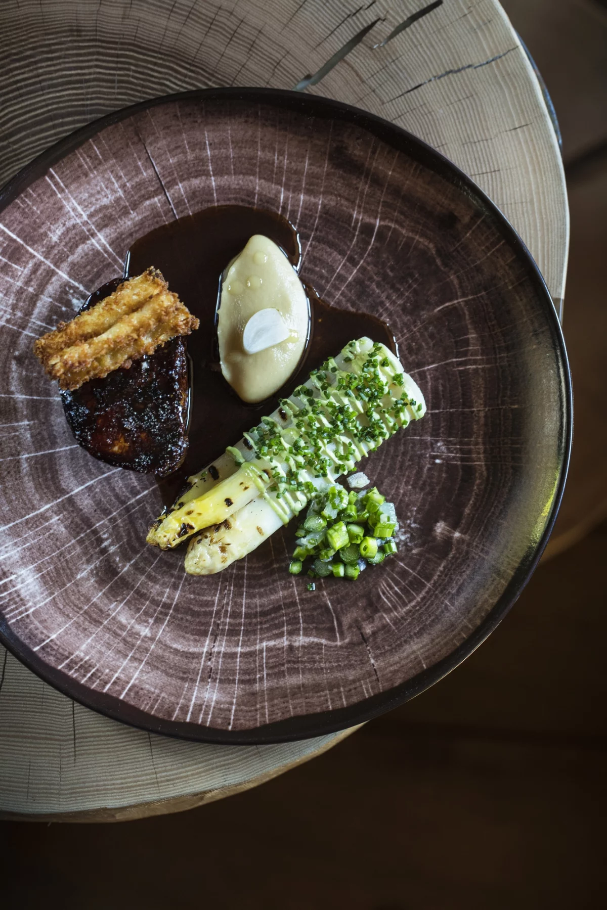 Quasi de veau, asperge d'Alsace à la braise, condiment d'ail fumé, et jus corsé. Photo Matthieu Cellard.