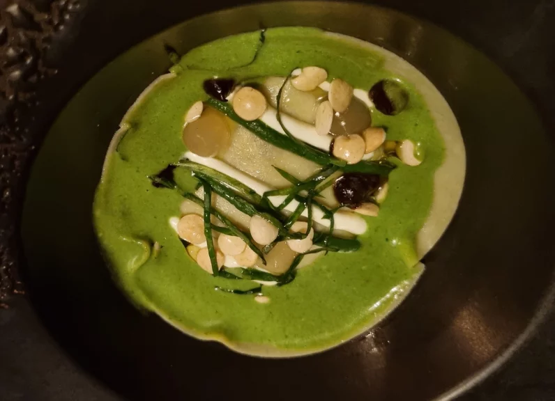 Escargots en raviole de pâte fraîche, sauce cresson, ail noir et gel de verjus.