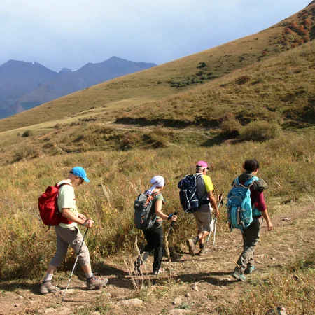 Un groupe de 5 personnes qui randonnent en basse montagne